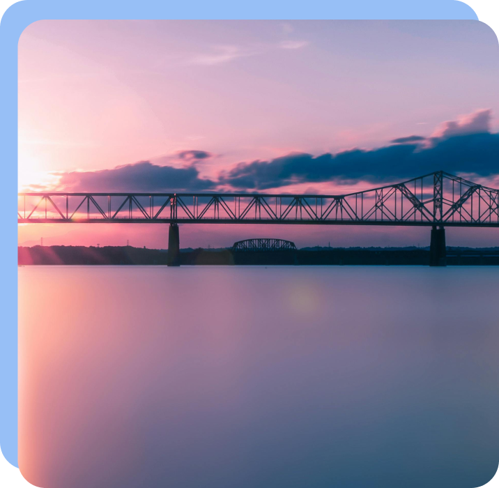 Bridge across calm water at sunset