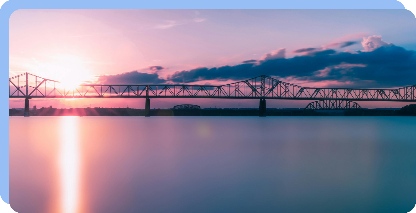 Bridge across calm water at sunset